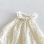 Close-up of 3D flower collar on ivory baby bubble romper