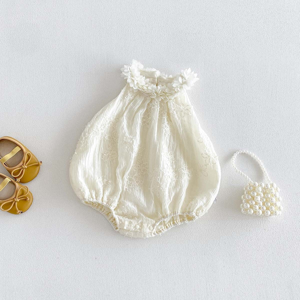 Baby ivory floral romper back view with snap fastening